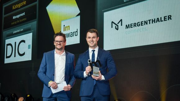 Jonathan Wieberneit (rechts im Bild) nimmt den imAward 2022 für das Projekt "Mergenthaler Connects" entgegen. (Credit: immobilienmanager/Steffen Hauser)