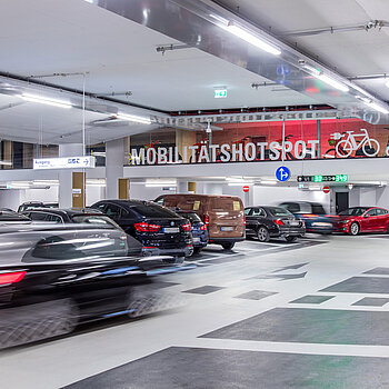 Mehr als Parken: Im verglasten Basement im 1. OG der Parkgarage warten emissionsfreie Verkehrsmittel für die letzte Meile und eine XL-Paketstation. Parken, Altstadt, München, TOM, Mobilitätshotspot, Thomas-Wimmer-Ring, Paketstation, Bike-Sharing, ERöffnung, Hofbräuhaus Parkgarage